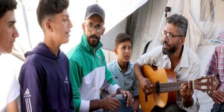 معلم نازح في غزة يزرع الأمل في قلوب الأطفال عبر الموسيقى