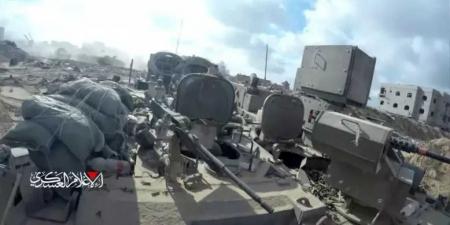 مقاتل من القسام يعتلي ناقلة جندي إسرائيلية ويلقي عبوة ناسفة في قمرة القيادة ”فيديو”